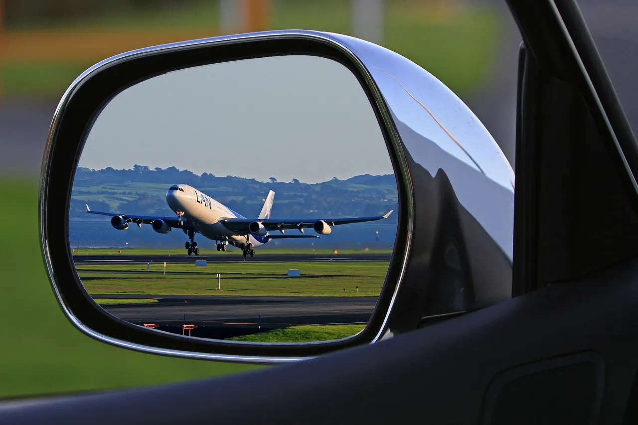 Plane seen in a car mirror